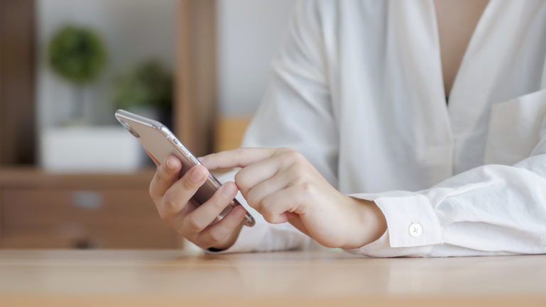 スマホで申し込みを行う女性の画像