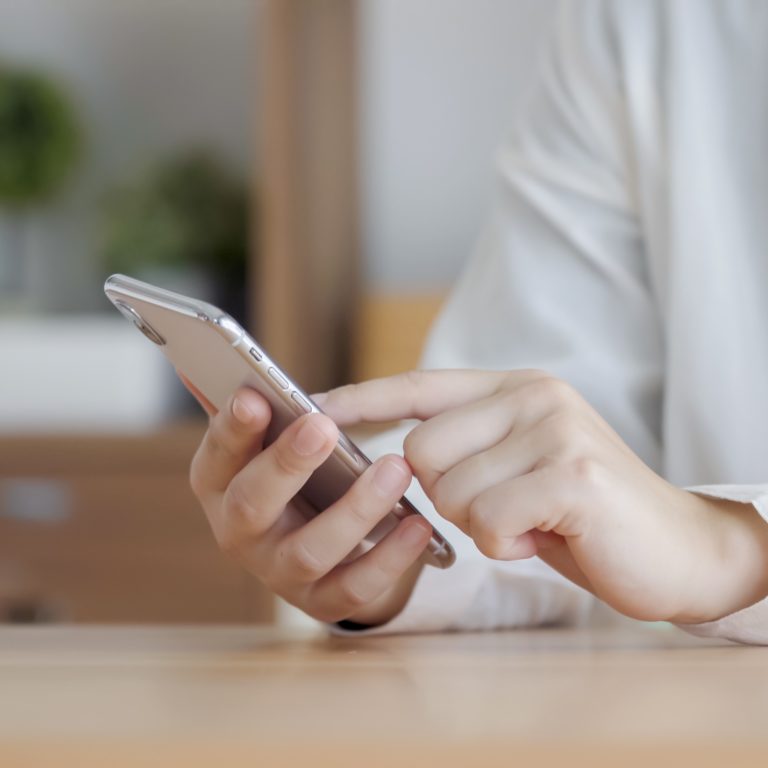スマホで申し込みを行う女性の手の画像