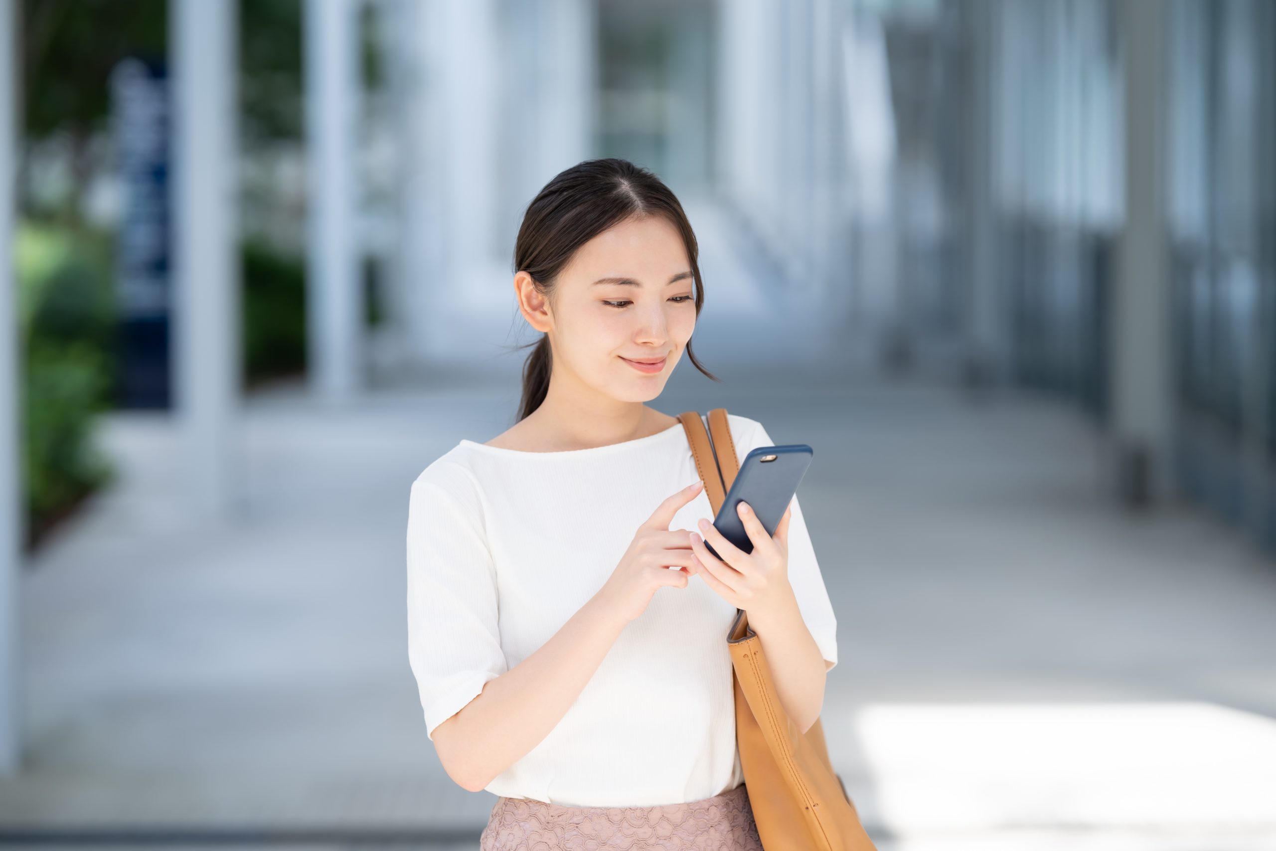 スマホで申し込みを行う女性の画像