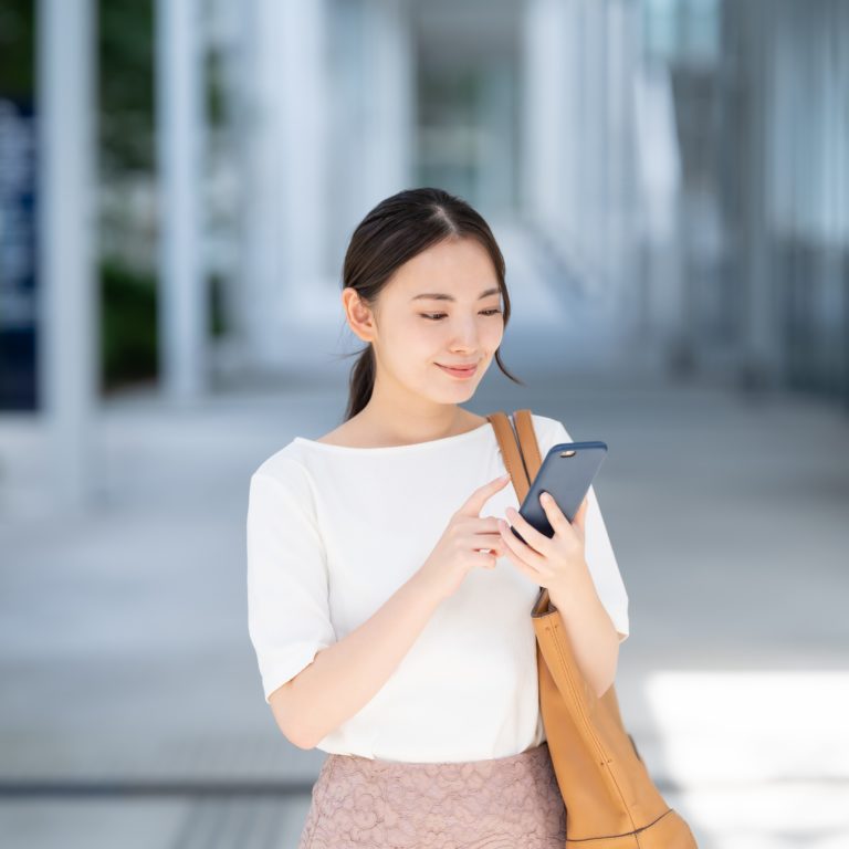 スマホで申し込みを行う女性の画像