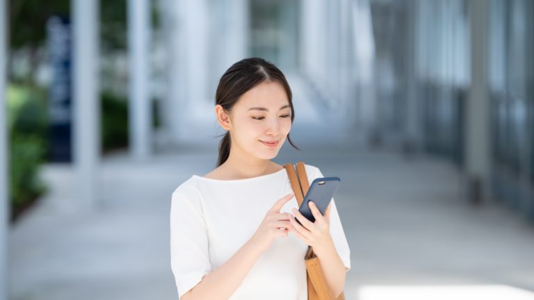 スマホで申し込みを行う女性の画像